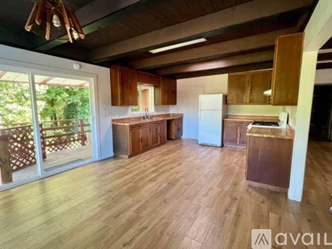 A kitchen with wooden floors and a white refrigerator.