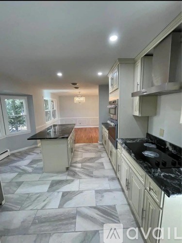 A kitchen with a black countertop and marble tiles.