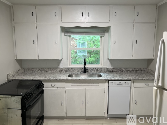 A kitchen with white cabinets and a black stove top oven.