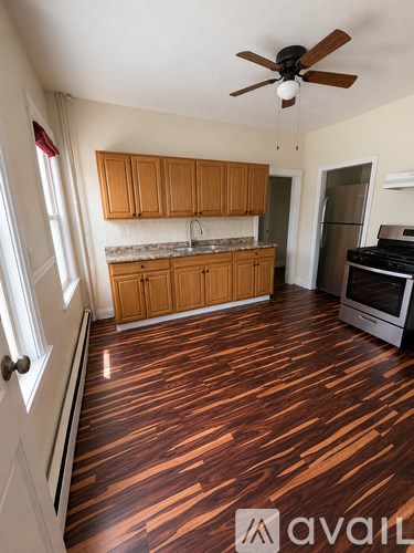 A kitchen with wooden floors and a ceiling fan.