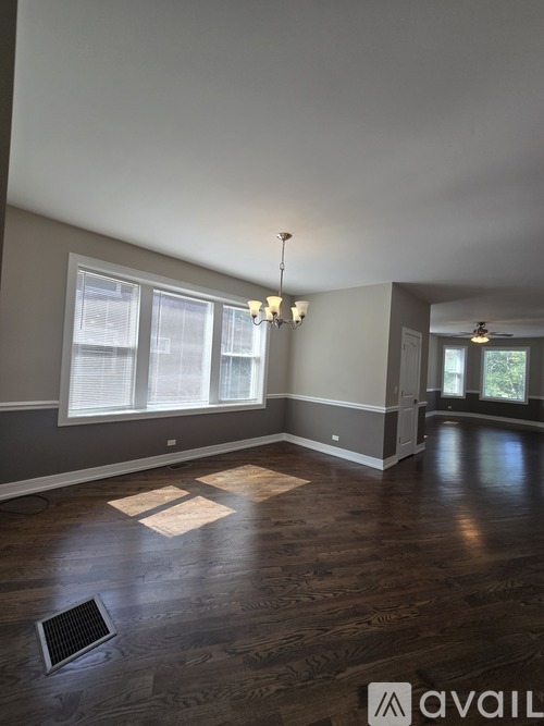 A room with wooden floors and a window with blinds.