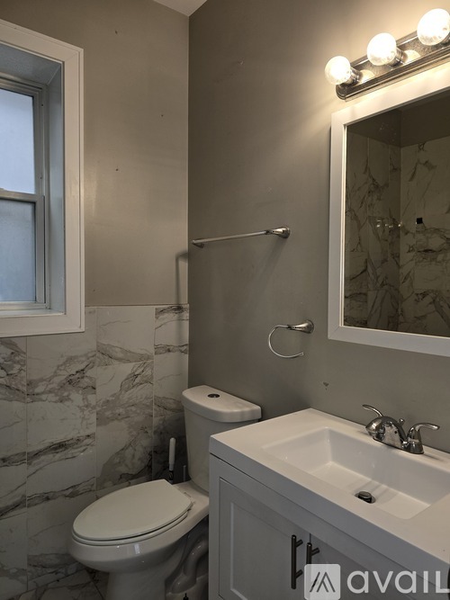 A bathroom with a toilet, sink, and mirror.