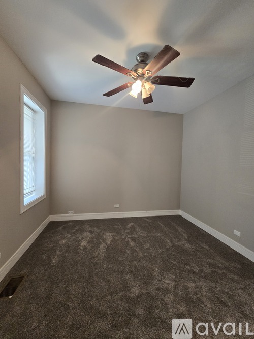 A room with a ceiling fan and carpeted floor.