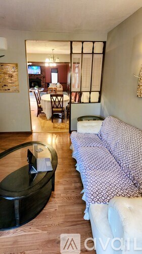 A living room with a couch and a glass table.