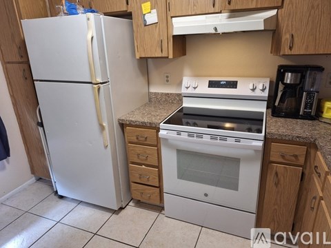 A kitchen with a white refrigerator, stove, and oven.