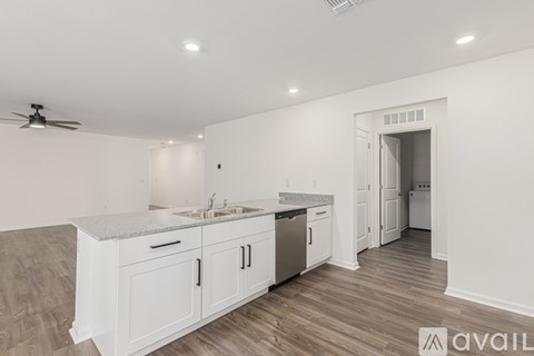 A kitchen with white cabinets and a marble countertop.
