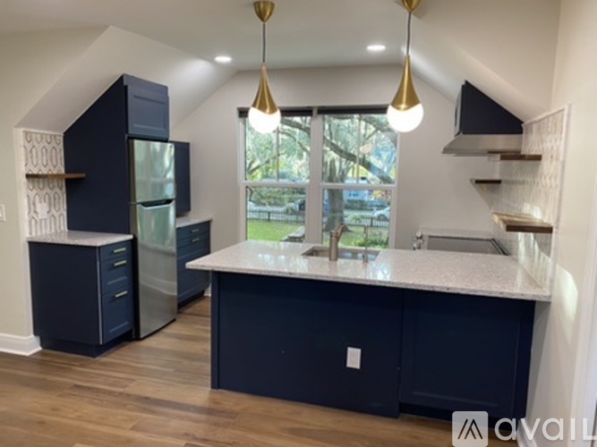 A kitchen with dark blue cabinets and a white countertop.