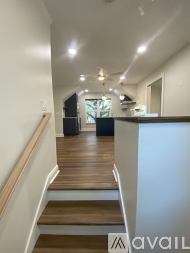 A long hallway with a staircase on the left and a kitchen area on the right.