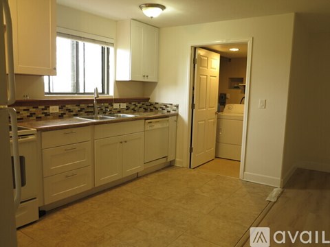 A kitchen with white cabinets and a brown counter top.