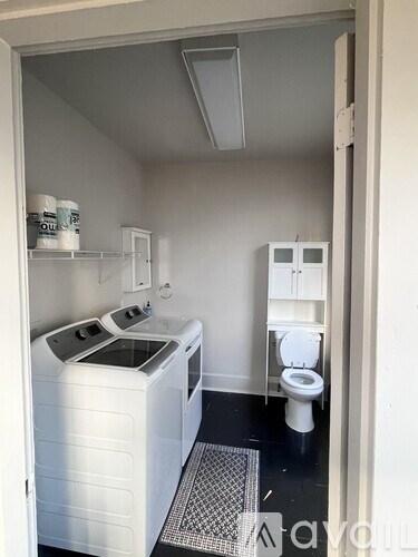 A small white laundry room with a washer and dryer.