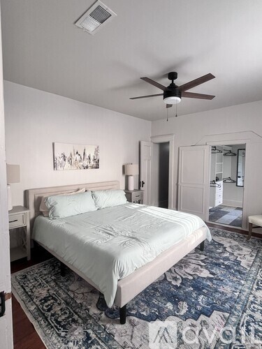 A bedroom with a large bed and a ceiling fan.