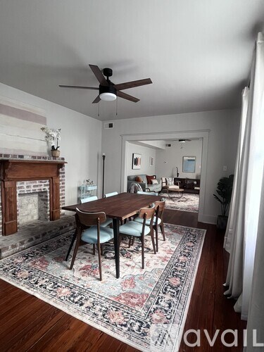A living room with a fireplace and a dining table.