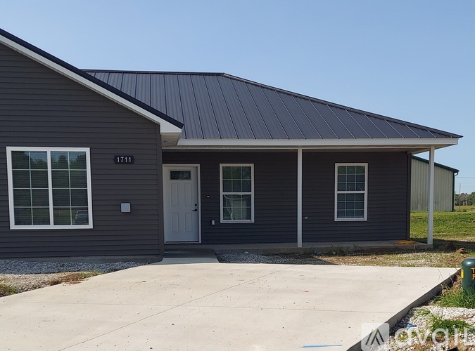 A house with a grey exterior and a white door.