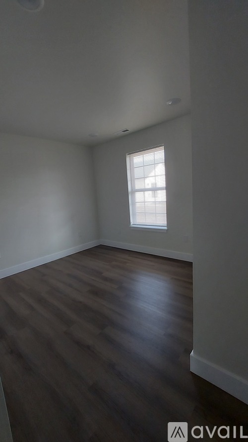 A room with wooden flooring and a window.