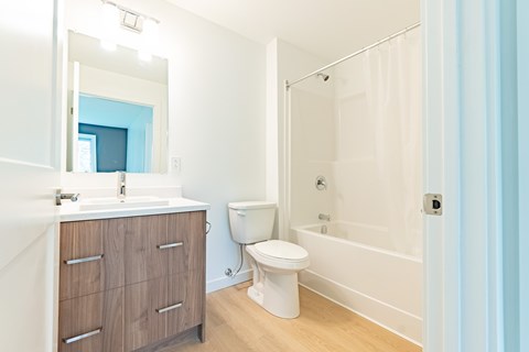 A white bathroom with a toilet, sink, and bathtub.