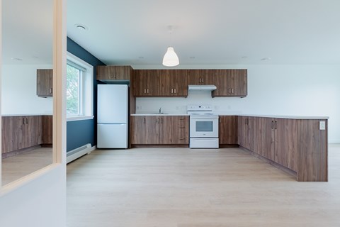 A kitchen with white appliances and wooden cabinets.