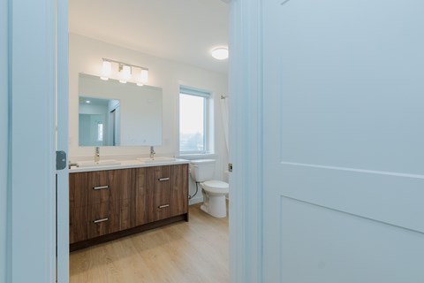 A bathroom with a toilet, sink, and mirror.