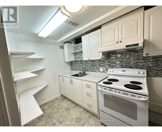 A kitchen with white cabinets and a white stove top oven.