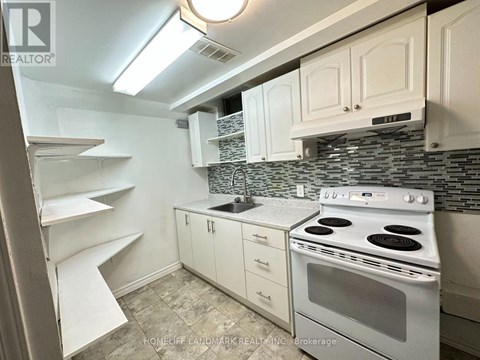 A kitchen with white cabinets and a white stove top oven.