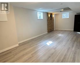 A room with wooden flooring and a brick wall.