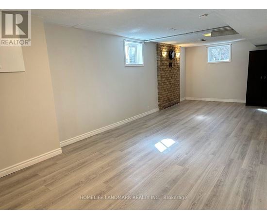 A room with wooden flooring and a brick wall.