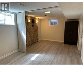A room with a brick wall and wooden flooring.