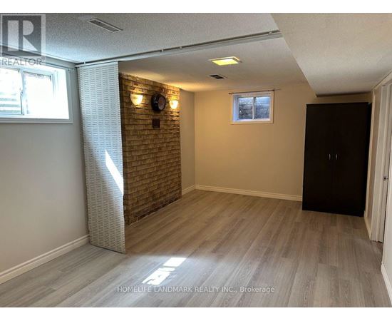 A room with a brick wall and wooden flooring.