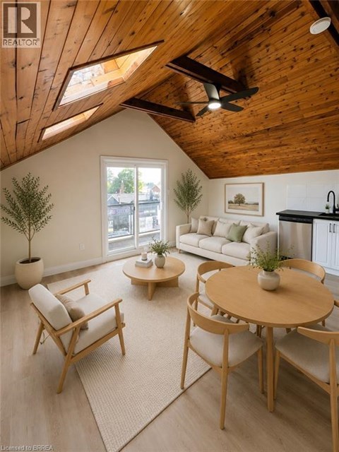 A living room with a wooden ceiling and a round table with chairs.