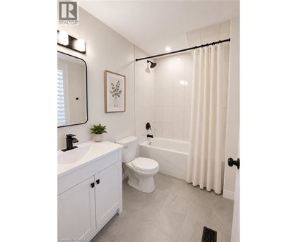 A white bathroom with a toilet, sink, and bathtub.