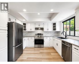 A modern kitchen with white cabinets and stainless steel appliances.