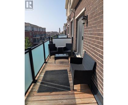 A balcony with a table and chairs.