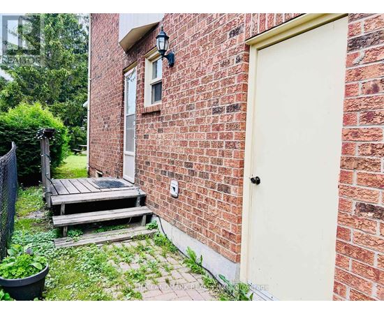 A red brick house with a white door and a small porch.