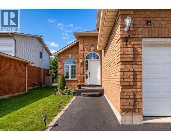 A house with a white garage door and a brick wall.