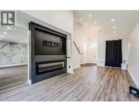 A modern living room with a fireplace and a flat screen TV.