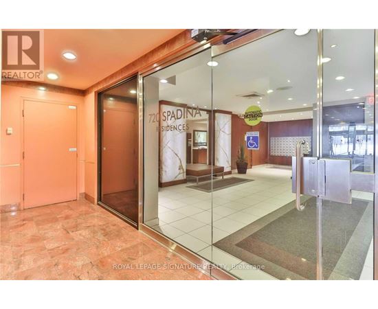 The image shows the entrance to a Spadina residences building with a glass door and a Royal LePage sign.
