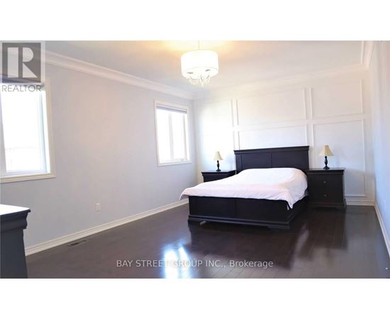 A bedroom with a large bed and a chandelier.