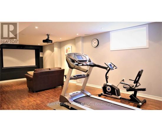 A home gym with a treadmill, exercise bike, and a couch.