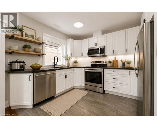 A modern kitchen with white cabinets and stainless steel appliances.