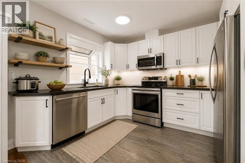 A modern kitchen with white cabinets and stainless steel appliances.