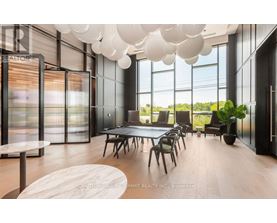 A modern dining room with a long table and chairs.
