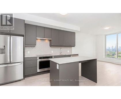 A modern kitchen with a stainless steel refrigerator and a large island.