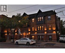 A Mercedes-Benz car is parked in front of a brick building.