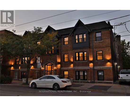 A Mercedes-Benz car is parked in front of a brick building.