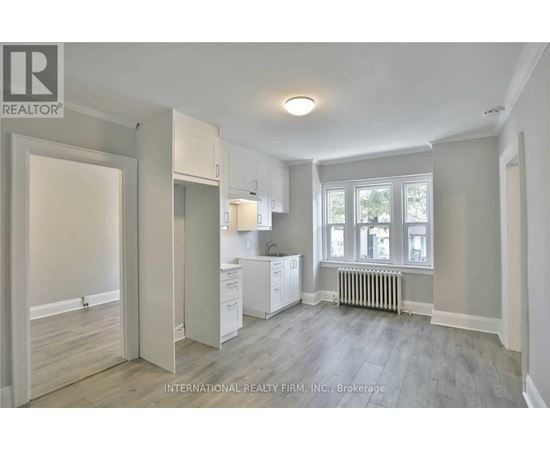 A spacious, empty room with a window and a radiator.