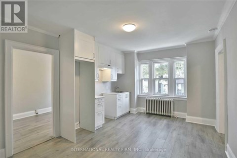 A spacious, empty room with a window and a radiator.