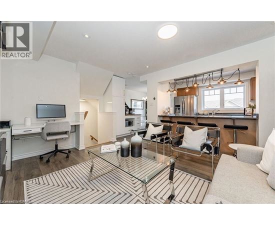 A well-lit living room with a glass coffee table and a television.