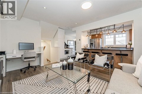 A well-lit living room with a glass coffee table and a television.