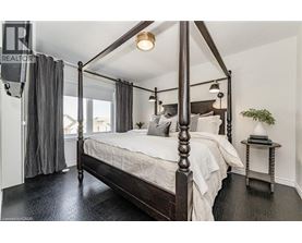 A bedroom with a four-poster bed and a small table.