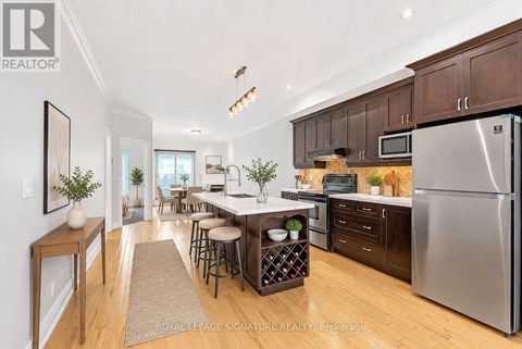 A kitchen with wooden floors and stainless steel appliances.