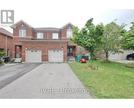 A large brick house with a driveway in front.